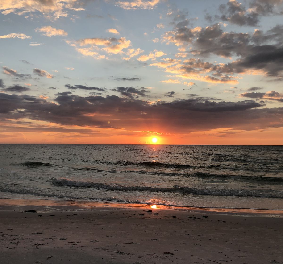 Sunset over the Gulf of Mexico from Clearwater Beach, with gentle waves on the sand