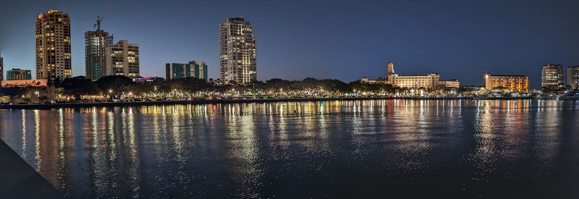 Downtown St. Petersburg waterfront at dusk, with city lights reflecting on Tampa Bay